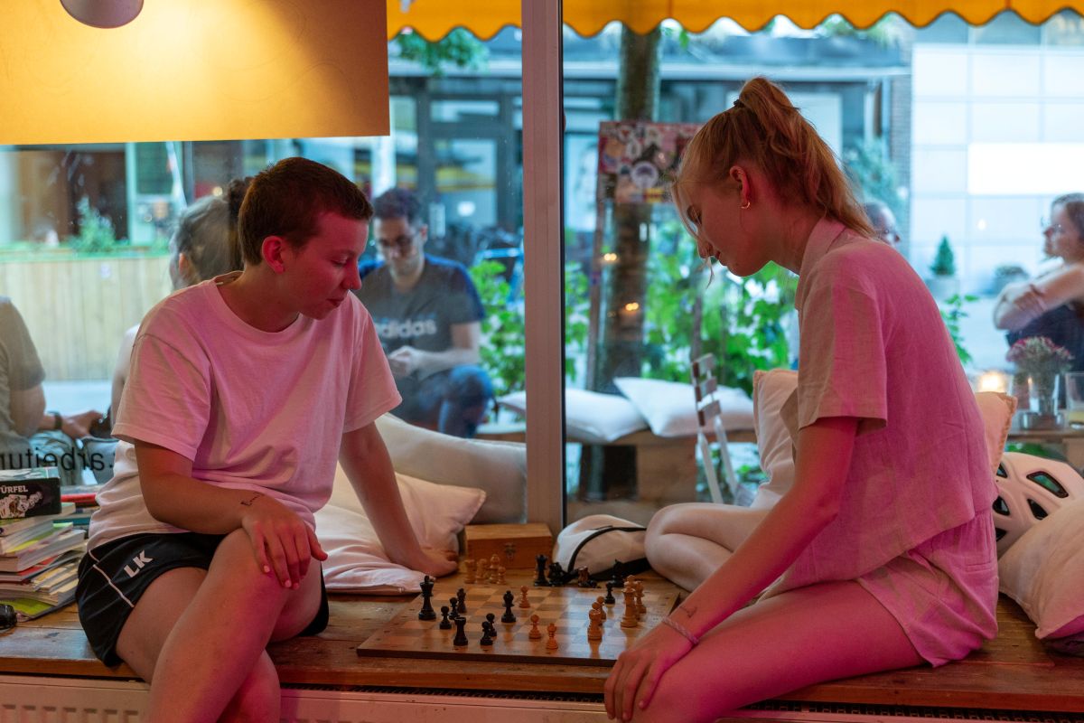 Zwei junge Menschen spielen Schach im raum café