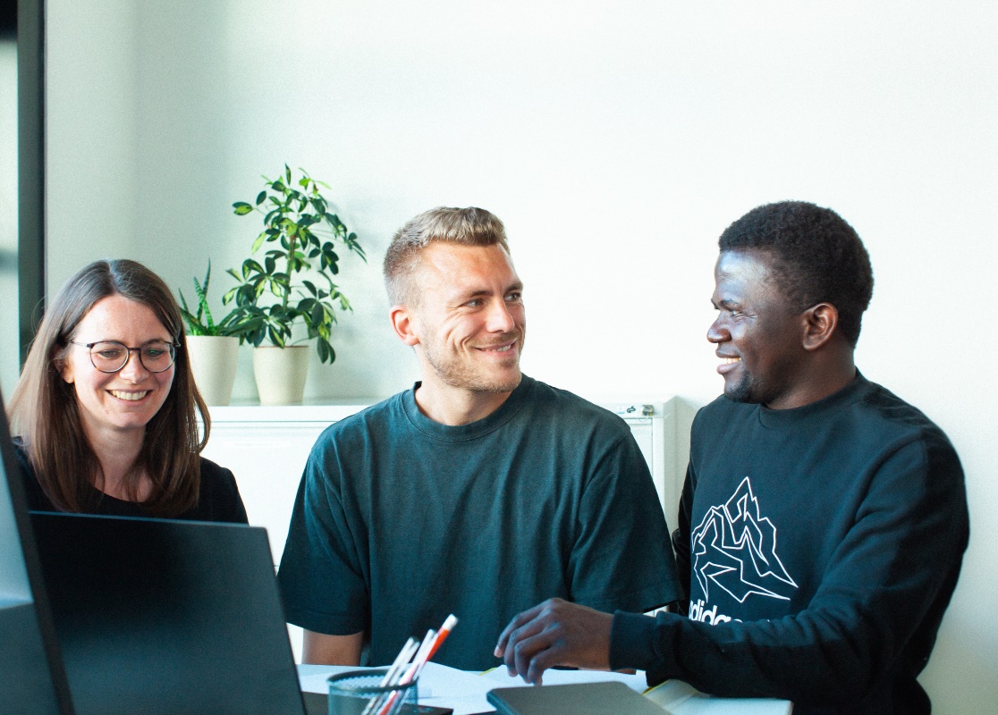 Zwei Expert*innen von socialbee im Gepräch mit einem Teilnehmer eines Absolvierungprogramms