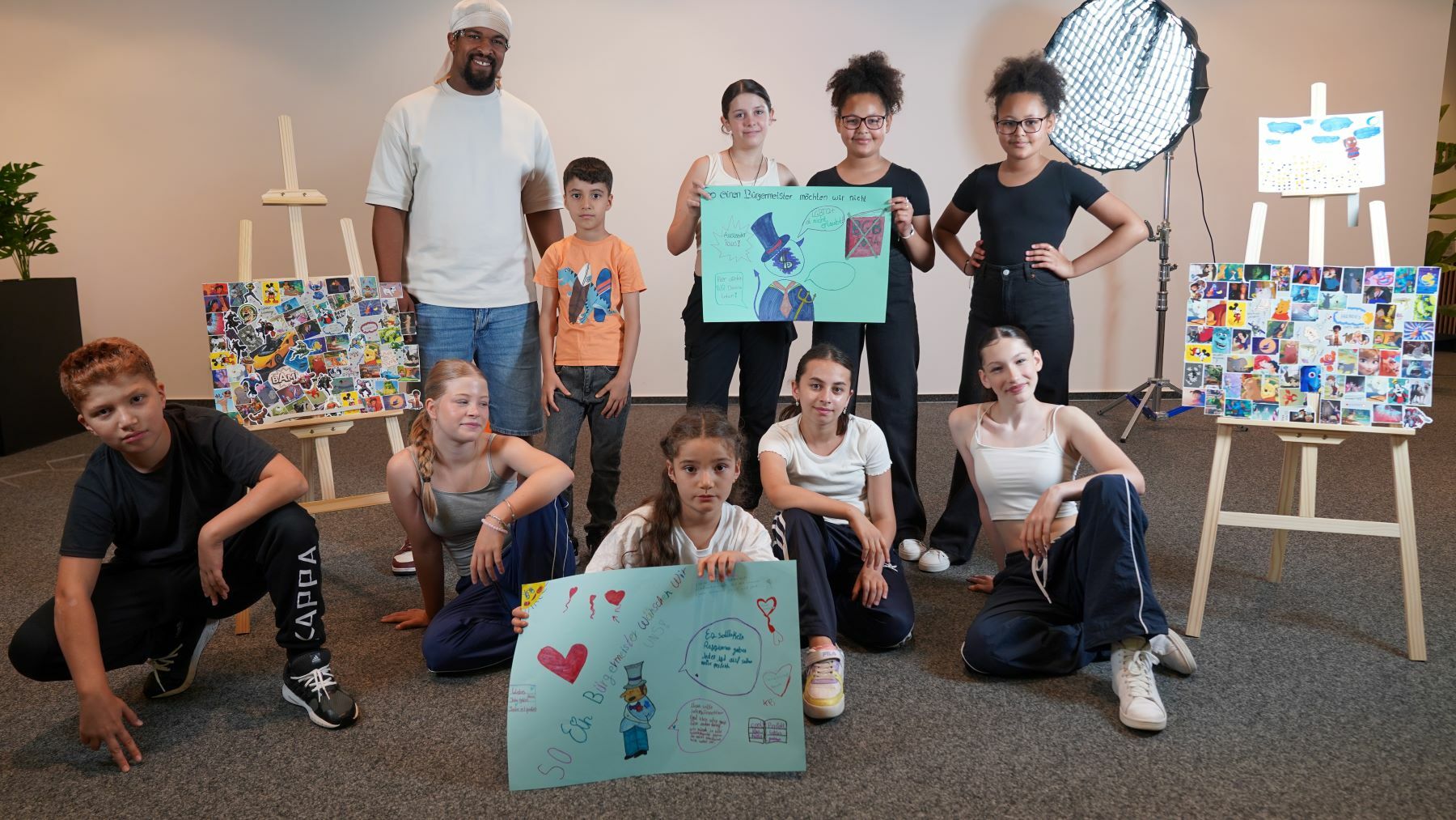 Teilnehmende des Projekts halten Plakate hoch